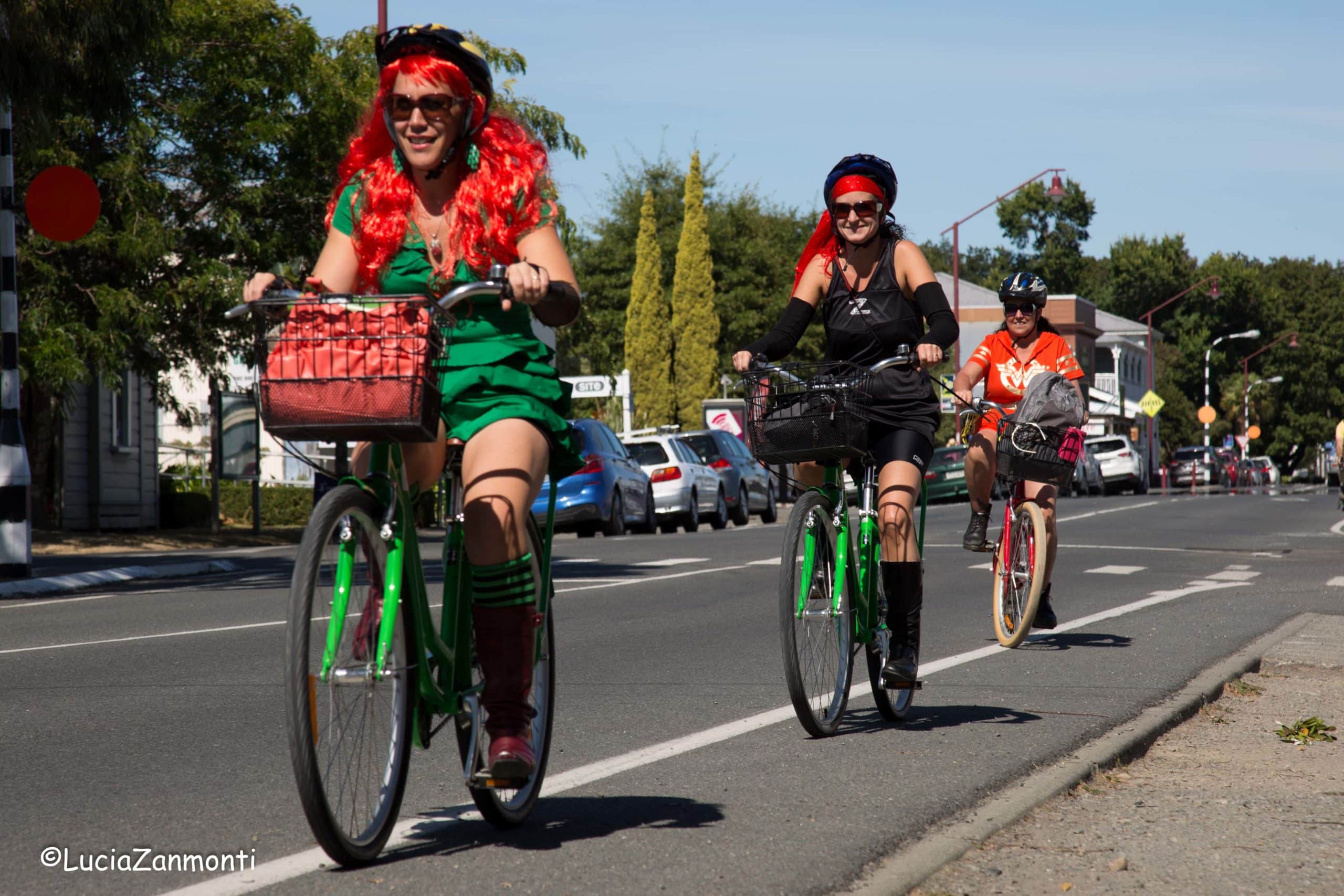 Three people riding hire bikes along a Martinborough street