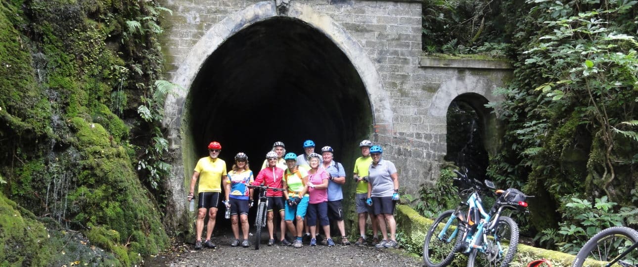 Cyclists posing outside the Summit Tunnel on Remutaka Rail Trail