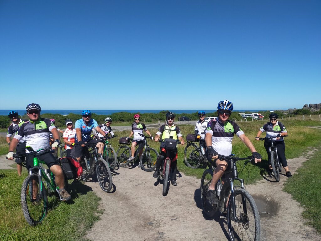 A Green Jersey tour group with their bikes beside the sea