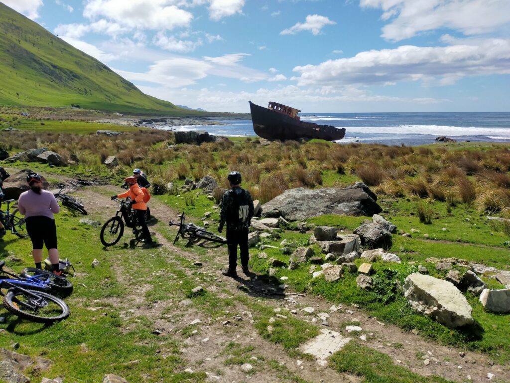 Riders stopped above a shipwreck on the Wairarapa coast