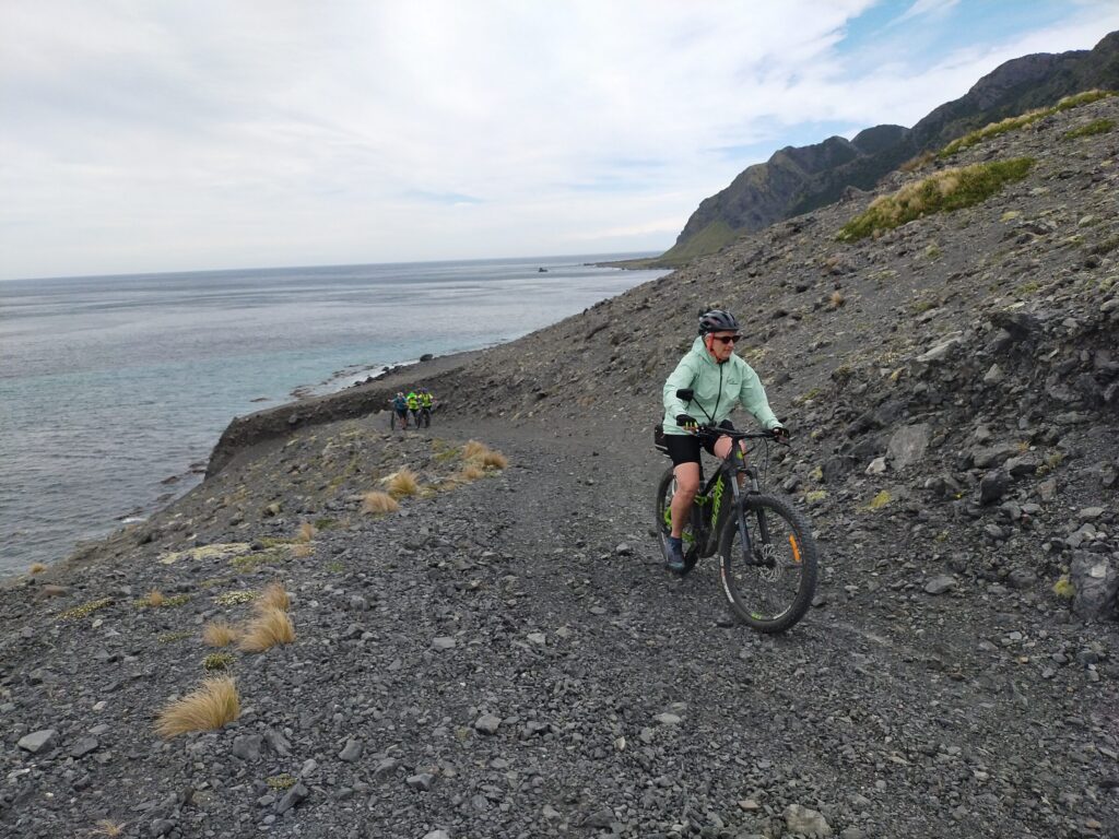 A rider on the shingle track above the sea at Ngapotiki